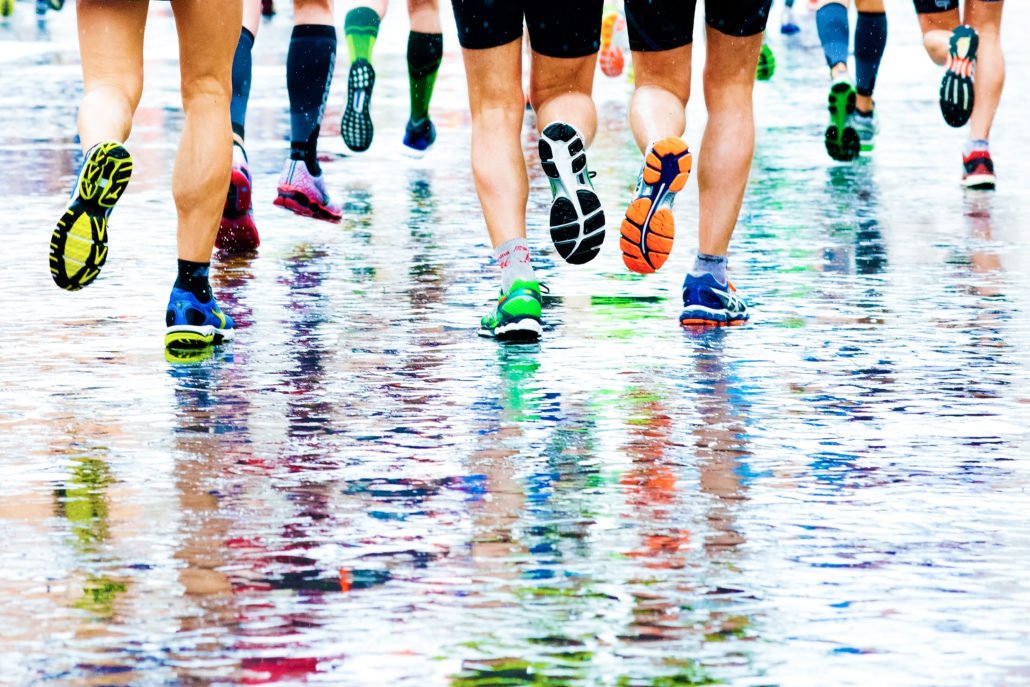 sportifs qui courent sur un sol humide